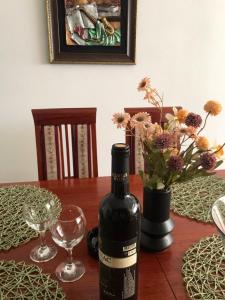 una botella de vino sentada en una mesa con una copa en Apartman Lana en Bajina Bašta