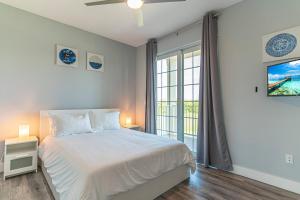 a white bedroom with a bed and a window at 3274 Little Harbor in Ruskin