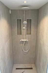een douche met een douchekop in de badkamer bij Aventure in Noordwijk