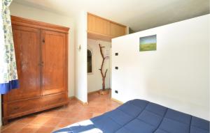 Ponte CaffaroにあるNice Apartment In Bagolino With Kitchenのベッドルーム1室(青いベッド1台、木製のドア付)