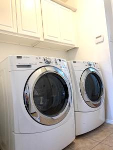 duas máquinas de lavar roupa sentadas uma ao lado da outra numa cozinha em Room Downtown Dallas em Dallas