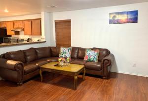 a living room with a brown leather couch and a table at Room Downtown Dallas in Dallas