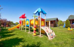ein Spielplatz mit einer Reihe von Rutschen auf einem Feld in der Unterkunft Domki Bartek in Darłowo