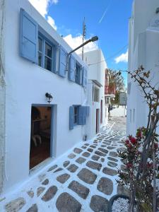 a white building with a doorway on a street at Windmill House Mykonos in Megali Ammos