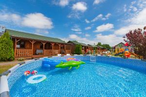 ein Schwimmbecken mit einem Spielzeughai in der Mitte in der Unterkunft Domki Bartek in Darłowo