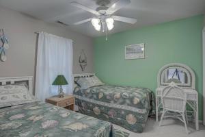 a bedroom with two beds and a ceiling fan at Lighthouse Seclusion in Ocean Pines