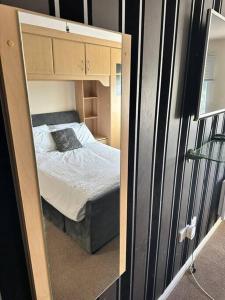 a mirror reflection of a bed in a bedroom at Abbey Wood Luxurious Flat. in Abbey Wood