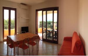 un soggiorno con tavolo e sedie e un balcone di Regina Apartments ad Alghero