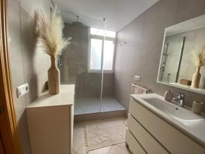 a bathroom with a shower and a sink and a mirror at Jandia Beach Apartment in Morro del Jable