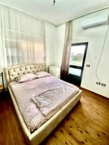 een slaapkamer met een bed in een kamer met een raam bij Villa Osmani in Durrës