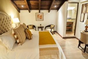 a bedroom with a large bed and a desk at Casa Faustina Boutique Hotel in Antigua Guatemala