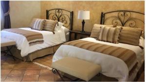 a bedroom with two beds and a chair at Casa Faustina Boutique Hotel in Antigua Guatemala