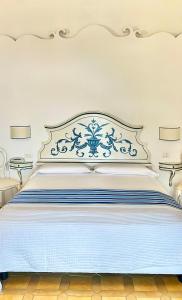 a large white bed with a blue and white headboard at Hotel Villa Delle Palme in Positano in Positano