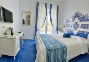 a bedroom with a bed and a desk and a window at Hotel Villa Delle Palme in Positano in Positano