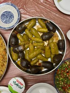 una mesa con una sartén llena de verduras y arroz en Petra Pass Hostel, en Wadi Musa