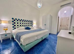a bedroom with a large bed with blue tiles at Hotel Villa Delle Palme in Positano in Positano