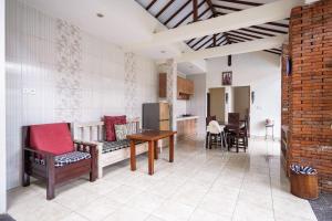 a living room with a table and chairs and a kitchen at The Janan Villa in Sanur