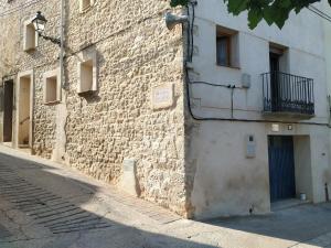 a brick building with a balcony on a street at Casa Vall Bona in Pobla de Masaluca