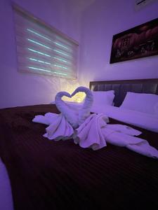 Dos cisnes haciendo un corazón en una cama en Petra Pass Hostel, en Wadi Musa