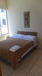 ein Schlafzimmer mit einem Bett mit zwei Handtüchern darauf in der Unterkunft HOTEL MICHELS in Candelária
