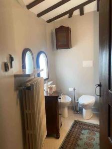 ein Badezimmer mit einem weißen WC und einem Waschbecken in der Unterkunft Castello ala Lucia in Monte Roberto