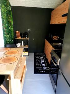 una cucina con pareti nere e ripiani in legno di Linda House a Casais de São Mamede