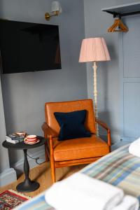 a room with a chair and a table with a lamp at Cosy City Centre First Floor Family Room in Edinburgh