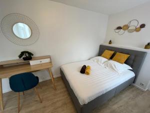 a bedroom with a bed and a table and a mirror at Le Voltaire in Melun