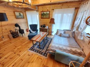 ein Wohnzimmer mit einem Sofa und einem Tisch in der Unterkunft Domek z bala na Podlasiu z balią ogrodową 