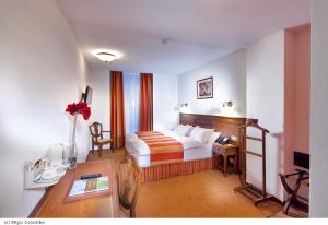 una camera d'albergo con letto e scrivania di Hotel AlaGare a Losanna