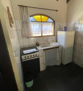 a small kitchen with a sink and a refrigerator at Chalés Água de Coco in Boicucanga