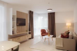 a living room with a couch and a tv at ZEN Garden Apartments in Cluj-Napoca
