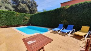 a patio with two chairs and a pool with a table and two chairs at Villa Pals Carles Piscina in Pals