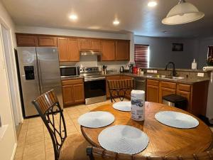uma cozinha com uma mesa de madeira com cadeiras e uma cozinha com electrodomésticos em aço inoxidável em Private room in Dallas em Dallas