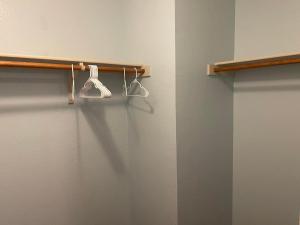 uma casa de banho com dois cabides brancos numa parede em Private room in Dallas em Dallas