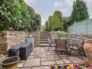 a patio with chairs and a stone wall at Hilston in Rhyl