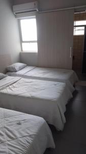 eine Gruppe von 3 Betten in einem Zimmer in der Unterkunft HOTEL ITAVERÁ BRASIL in Presidente Prudente