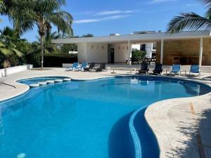 a large swimming pool with chairs and a house at Villa Navarro: Marina Vallarta in Puerto Vallarta