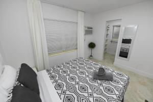 a white bedroom with a bed and a window at 4-PLEX in Fort Lauderdale
