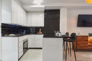 kuchnia z białymi szafkami i stołem z krzesłami w obiekcie Pintada Apartment in Nerja by Solaga Holiday Homes w mieście Nerja