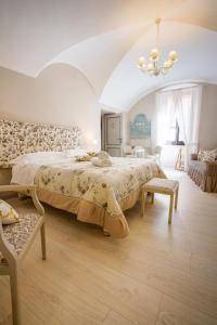 a bedroom with a large bed and a chandelier at Domo 'e sa rosa in Bosa