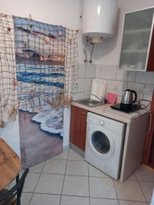 a kitchen with a washing machine in a kitchen at Studio ap ,NINI' in Supetar