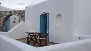uma pequena mesa e cadeira num quarto com paredes brancas em Nikos Country House em Naousa