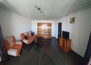 a living room with two chairs and a television at Blue Sky Apartament in Constanţa