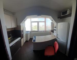 a small kitchen with a table and a window at Blue Sky Apartament in Constanţa