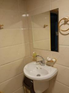 a bathroom with a white sink and a mirror at Yara camp in Wadi Rum