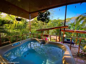 une baignoire jacuzzi sur la terrasse d'une maison dans l'établissement Bungalows Yakari Grei, à San Ramón