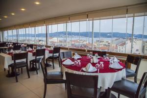 un comedor con mesas, sillas y ventanas en Çanak Hotel, en Canakkale