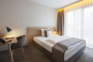 Postel nebo postele na pokoji v ubytování Fürstenfelder Hotel