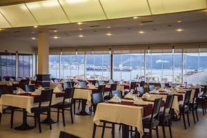 a dining room with tables and chairs and windows at Çanak Hotel in Çanakkale